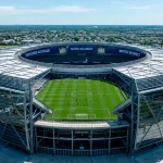 Vue aérienne d'un grand stade américain de football avec un terrain vert et une architecture moderne