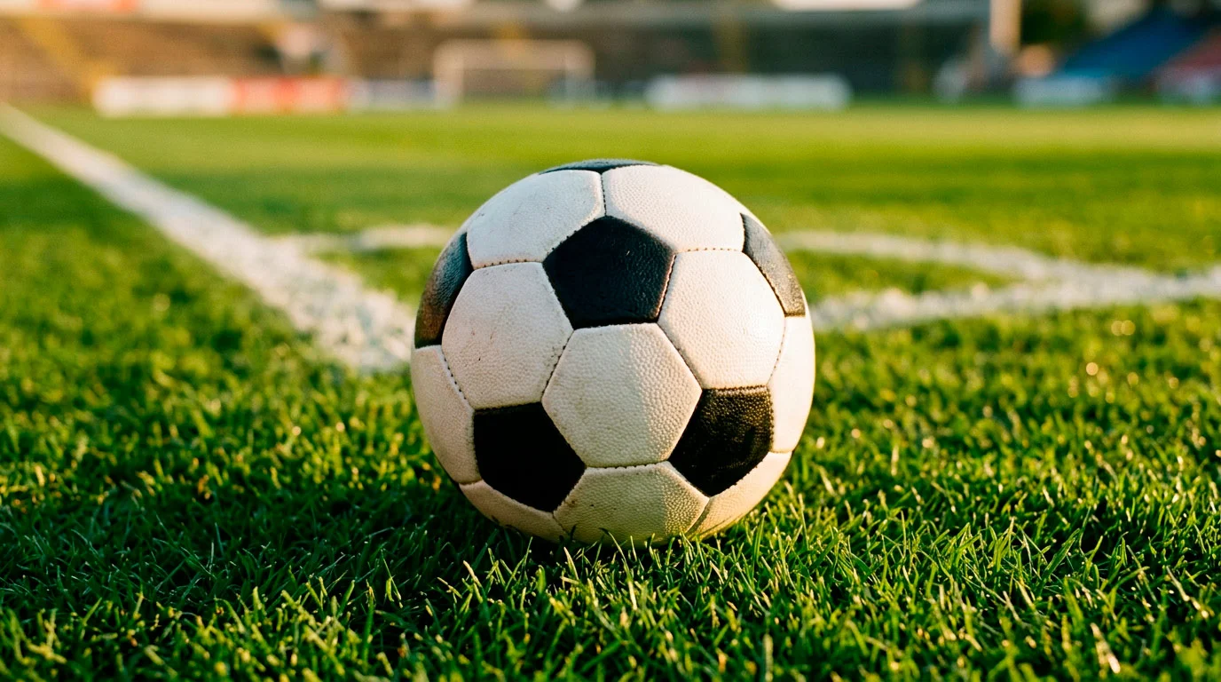 Ballon de football sur la pelouse d'un stade avec les lignes du terrain visibles en gros plan